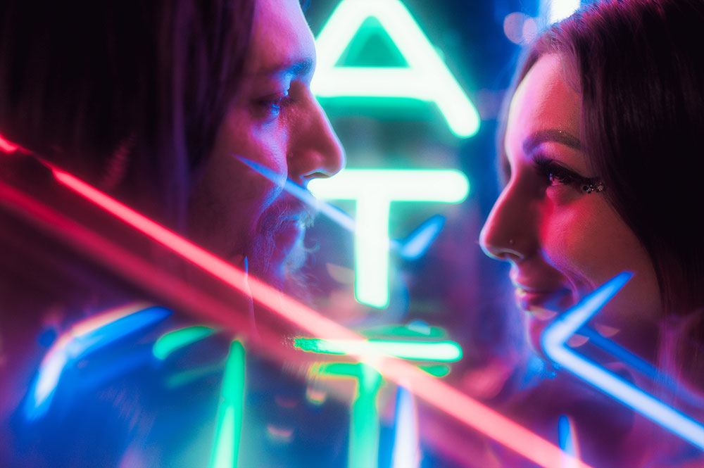 JT portrait of a couple, taken lit with neon signs