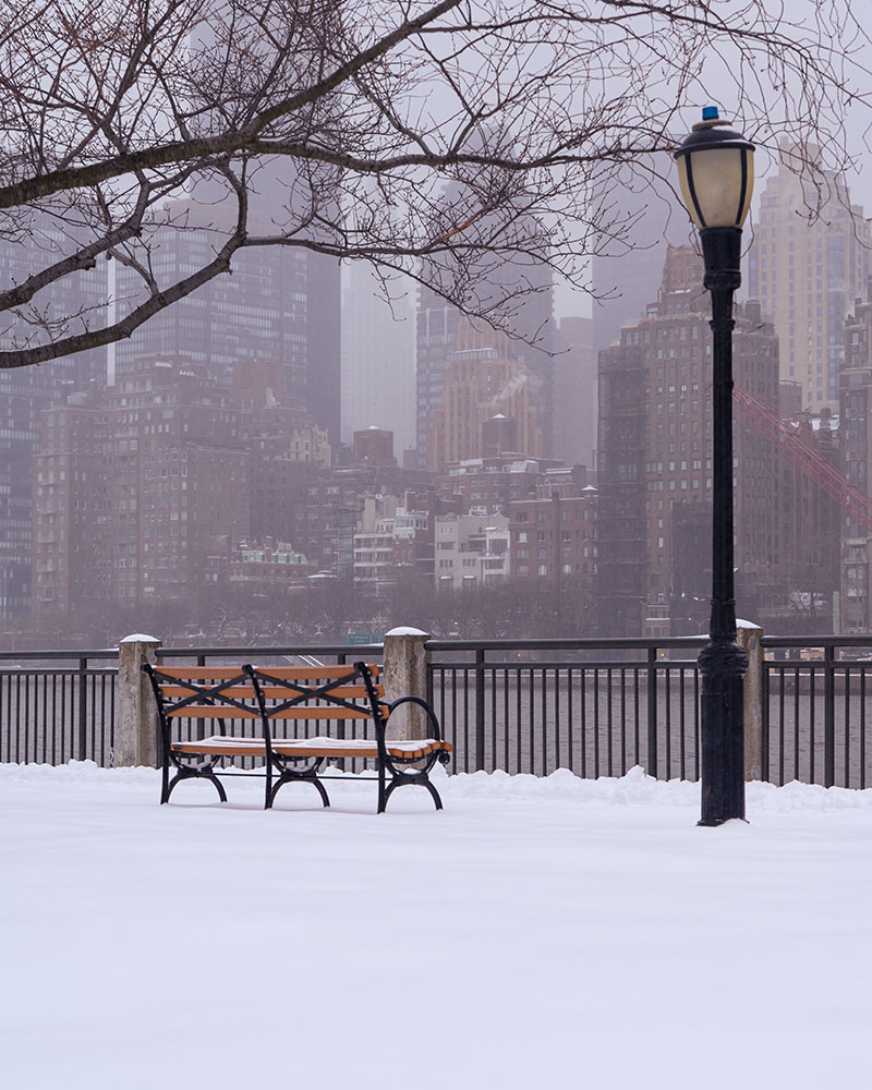 Manny Khan photo of a park bench and streetlamp in the snow